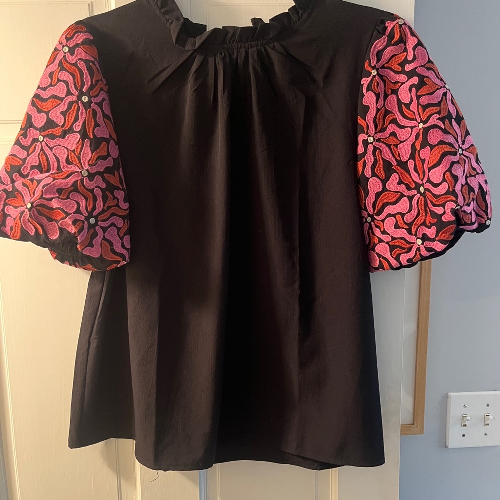 Black and Pink Women's Top with embroidered puffy sleeves and ruffle neckline.